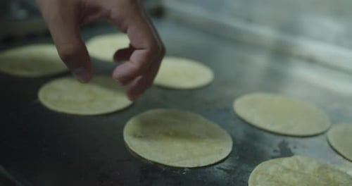 Beautiful general slow motion shot of a chef flipping a group of Mexican tortillas placed on a large