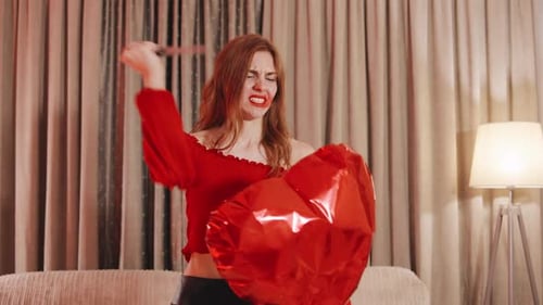Upset Woman Pops Heart Balloon with Knife