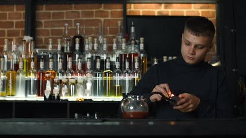 Bartender making unusual cocktail in a tea pot at the bar. Media. Adding smoke into the hot cocktail