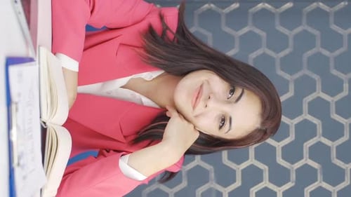 Smiling Woman Sitting at Desk in Bright Office
