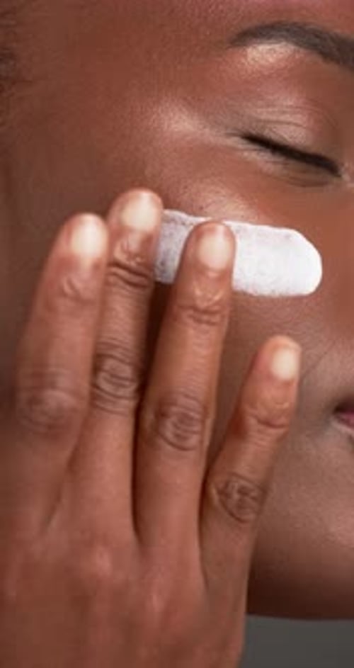 Cream, skincare and black woman with beauty, shine and dermatology on grey studio background