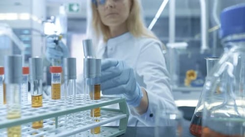 Vue du point de vue prise depuis un chariot en mouvement avec des tubes à essai, des analyses, des béchers et divers articles de verrerie. Sci