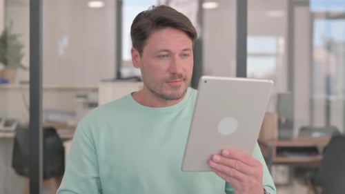 Man Using Tablet in Bright Office Space