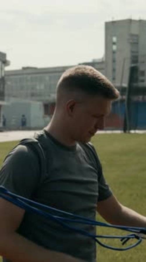 Male Para Athlete with Missing Hand Training with Elastic Bands at Stadium