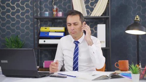 Man Working in Office on Phone at Desk