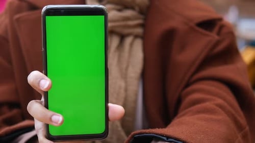 Close Up of Young Woman Hand Showing Smart Phone with Green Screen