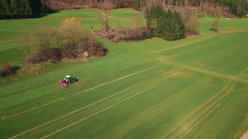 Tractor working on large green field