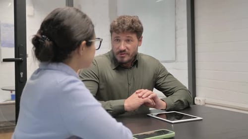 Colleagues Discuss Business at a Table in Office
