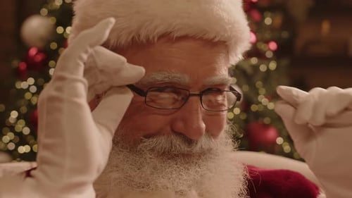 Portrait of Santa Putting off Glasses, Smiling and Looking at Camera