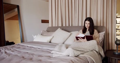 Woman Reading a Book in a Cozy Bedroom