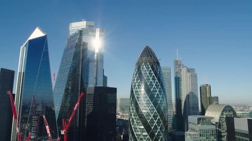 Rising aerial establishing shot of the financial district as the morning sun reflects on the iconic