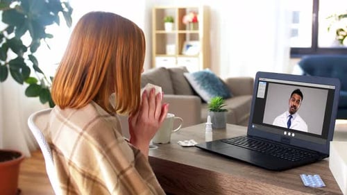 Woman consulting with doctor online at home