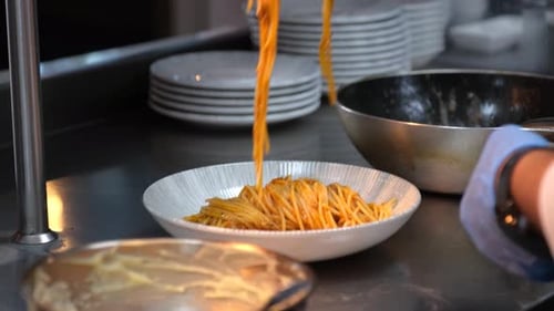 Chef Plating Delicious Pasta Dish in Kitchen