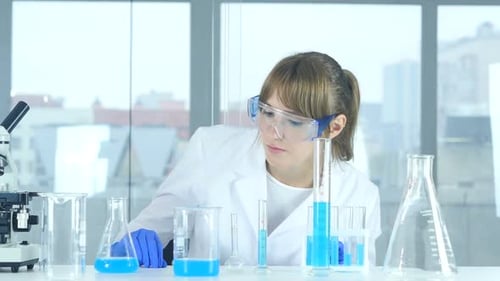 Scientist Conducting Experiment in Laboratory with Blue Liquid