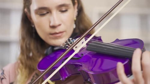 Close-up of musician woman playing violin at home. Composing, playing music.
