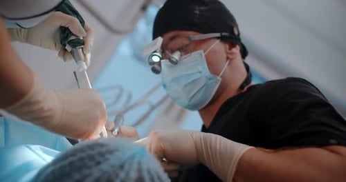 Portrait of the Dental Surgeon Doing the Surgery with Assistant in Dental Clinic