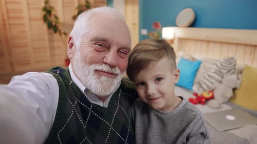 Grandfather and Grandson Smiling in Home Interior