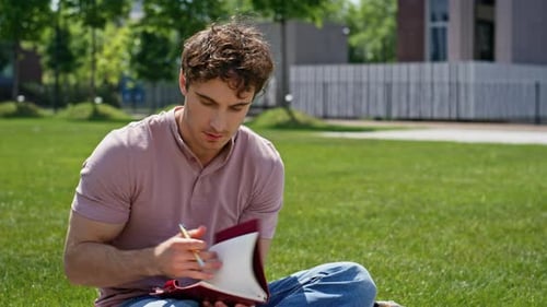 Man Writing Notebook Park Sunny Day Closeup Focused Student Immersed in Study