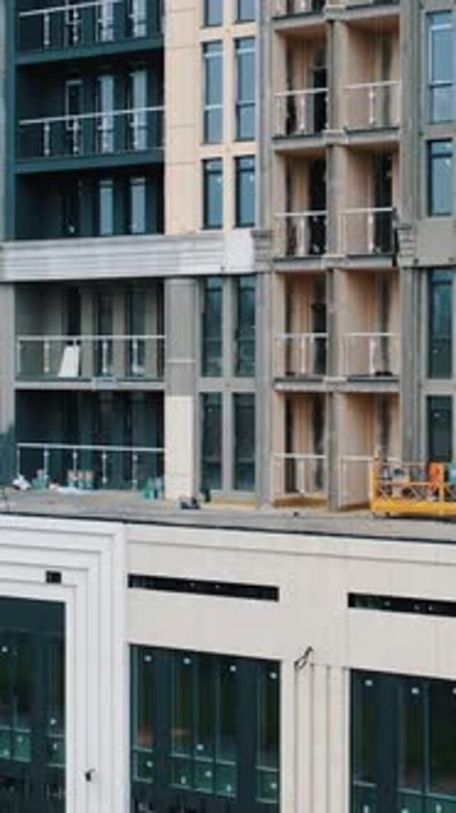 Edificio de apartamentos alto. Construcción de un edificio de apartamentos de varios pisos con ventanas y balcones