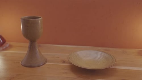 Brown porcelain Chalice and Paten - sacred ornaments on the wooden altar for Catholic Mass - dolly s