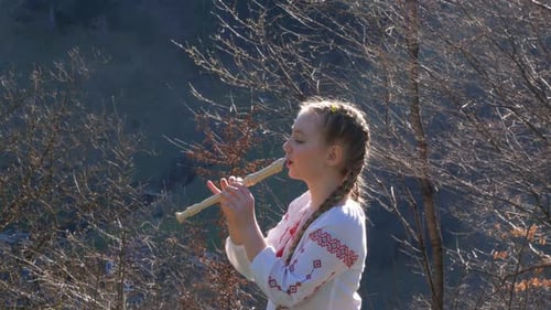 Young Woman Plays Flute Outdoors on Sunny Day