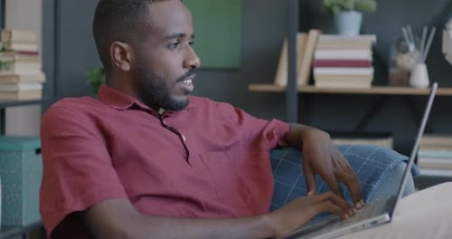 Man Using Laptop Computer While Relaxing at Home