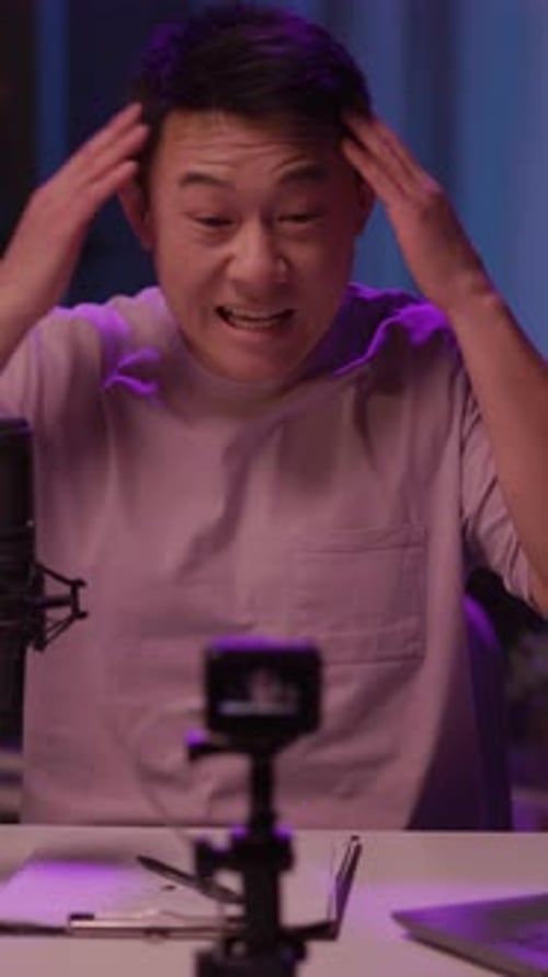 Man Records Podcast in Purple Light Indoors