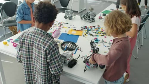 Verschiedene Kinder bauen im Robotics Club Modelle aus Kunststoffbausteinen