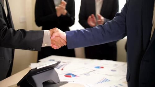 Businessmen Shake Hands After Meeting in Office