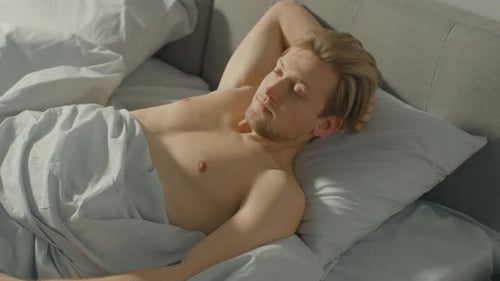 Man Sleeping in Bed Waking Up