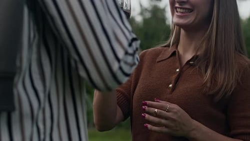 Couple multiethnique qui tinte des verres de vin rouge dans le jardin
