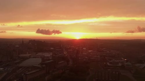 Aerial view of beautiful Edinburgh Scotland during dramatic sunset- Flying right to left