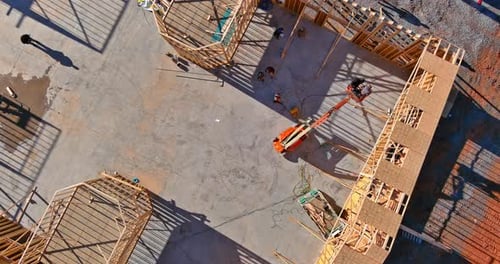 Ein Kran wird verwendet, um die Holzbalken der Dachstühle zu halten, während er in die
