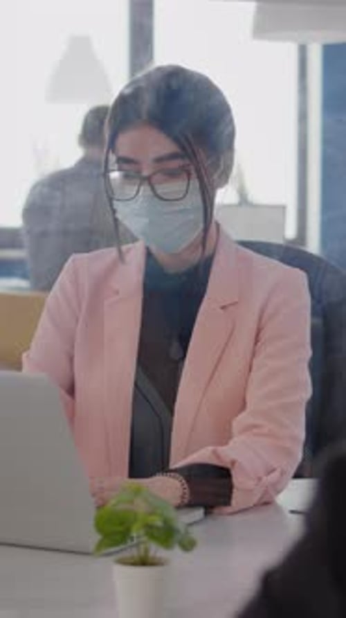 Woman Working on Laptop in Modern Office with Mask