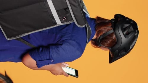 Delivery Person with Helmet Looking at Phone