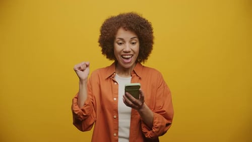 Woman Celebrating Achievement on Yellow Background