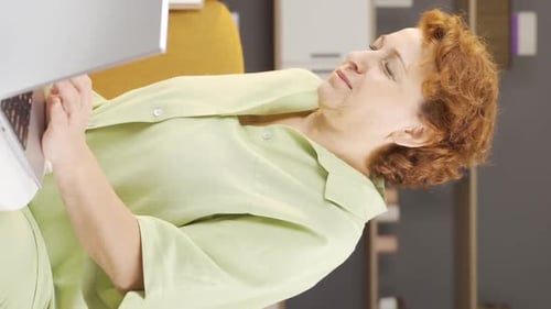 Woman Using Laptop Massages Knee in Discomfort