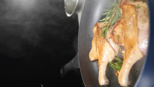 Duck Legs Frying with Rosemary in Pan