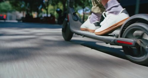 Une femme en gros plan conduit un scooter électrique en ville