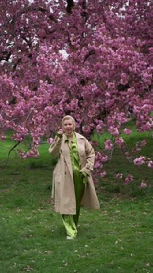 Woman Walking Near Blossoms in Spring Fashion