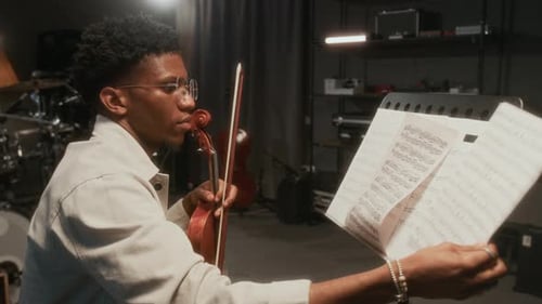 Violinist Reading Sheet Music in Studio