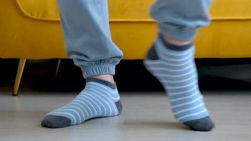 Dancing Feet Wearing Blue Striped Socks Indoors