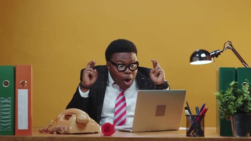 Man Celebrating at Desk with Confetti Falling