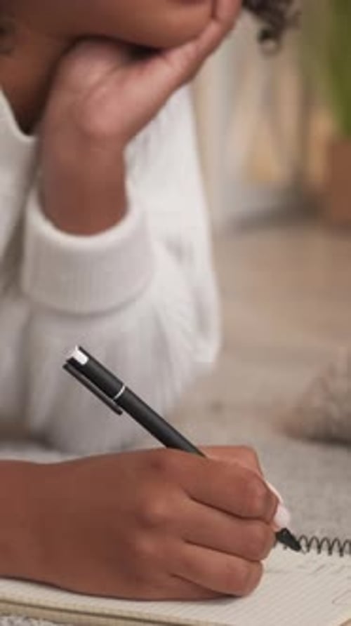 Woman Writes in Notebook on the Floor
