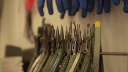 Detalhe da sala de trabalho cheia de alicates, pinças, divisores, limas e outras ferramentas em câmera lenta
