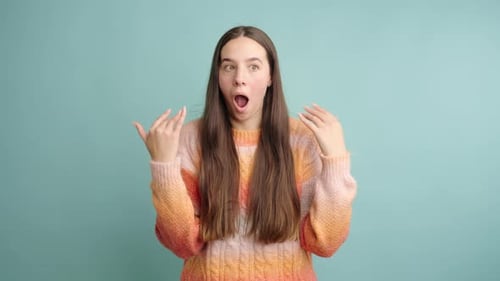 Excited Young Woman Making Gestures Against Blue Background