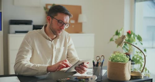 Businessman Browsing Through Tablet PC at Office