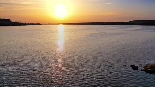 Beautiful sunset is reflecting in the river. Sunset lake landscape. Colorful sky.