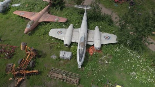 Derelict Airplanes and Farming Machines in Grassy Field