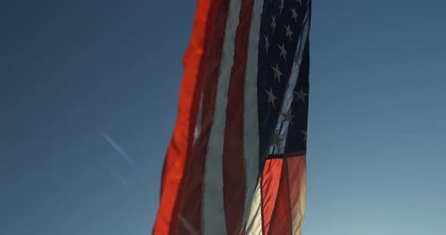 American Flag Waving in the Wind Under Sunlight